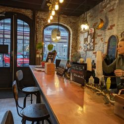 Roots Wellness Bar - Awesome vibes in this shop set in a historic building with large arched windows, exposed brick, long copper bar top with comfy stools.