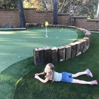 Biltright Turf - After - an awesome putting/chipping green with landscaped retaining wall - Landscaping Near Me
