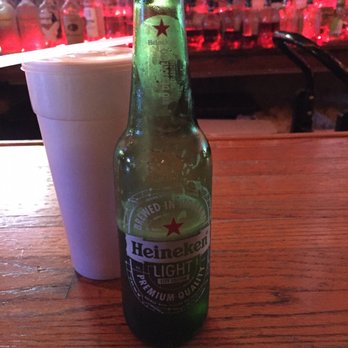 Pit Stop Saloon - a bottle of heineken beer next to a white cup - Dive Bars Near Me - Luling, Louisiana