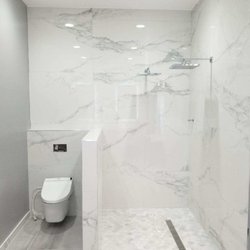 Advanced Contractors - 30x60 wall & floor tile. Toto in wall toilet w floating bowl. Curbless shower with linear drain, 2 shower heads, app controlled shower valve