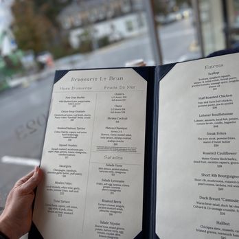 Brasserie Lebrun - a person holding a menu - French Near Me - Bar Harbor, Maine