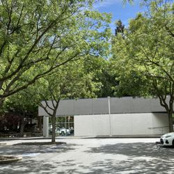 He has a small triangular building next to a water fountain. It's unmarked, but look for the pointed edge.