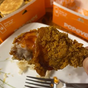 Popeyes Louisiana Kitchen - a hand holding a piece of fried chicken - Fast Food Near Me - Everett, Washington Popeyes Louisiana Kitchen - a hand holding a piece of fried chicken - Fast Food Near Me - Everett, Washington