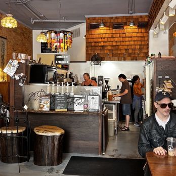 Fawn River Coffee - Friendliest Baristas in Lagrange working hard to produce some delicious coffee - Fawn River Coffee's interior features a counter with baristas, warm lighting, and wooden decor, with customers and seating visible. - Coffee & Tea Near Me - Lagrange, Indiana