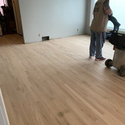 a man working on a hard wood floor a man working on a hard wood floor