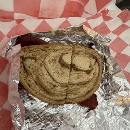 There were three slices of pastrami spread across this sandwich. There were three slices of pastrami spread across this sandwich.