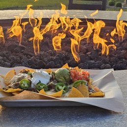 High top fire pit table with nachos.