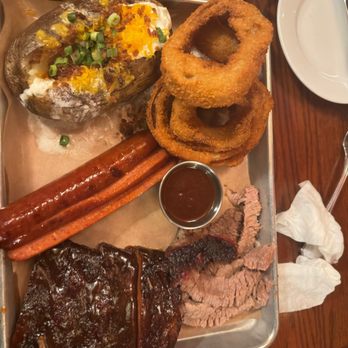 Back Forty Texas BBQ - Grand pit with onion rings, baked potato, hot link, ribs, and juicy brisket. - American Near Me - Pleasant Hill, California