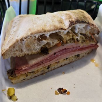 Hangar 502 - MUFFULETTA: Pistacchio mortadella, hot capicola, soppressata, & provolone cheese served on focaccia & topped w/ house-made olive tapenade - Delis Near Me - Boulder City, Nevada