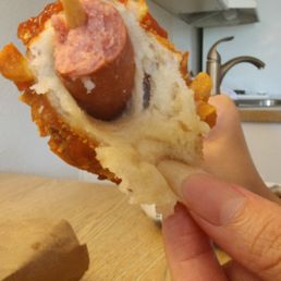 Raw stretchy dough around warm hotdog. Raw stretchy dough around warm hotdog.