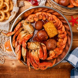Red Crab Juicy Seafood - Crab, shrimp, corn and red potatoes swimming in bold Cajun butter--messy, saucy and made for serious seafood cravings.