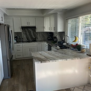 Lifetime Flooring - a kitchen with white cabinets and marble countertops - General Contractors Near Me - Anaheim, California