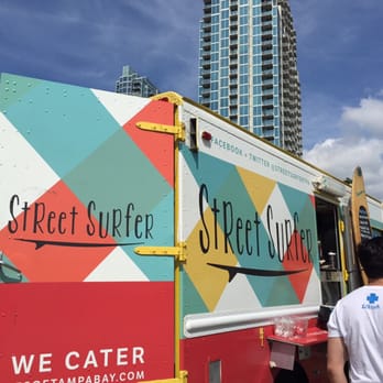 Street Surfer - a food truck parked in front of a tall building - Food Trucks Near Me Street Surfer - a food truck parked in front of a tall building - Food Trucks Near Me