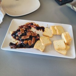 Brie cheese with balsamic vinegar, fruit and pecans