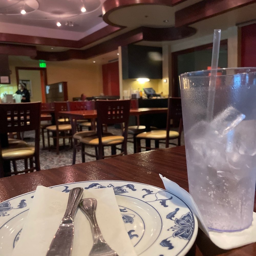 a glass of water and a plate with a fork on it a glass of water and a plate with a fork on it