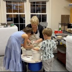 Art House 7 - Teacher Lore Potoker guides kids using a pottery wheel.