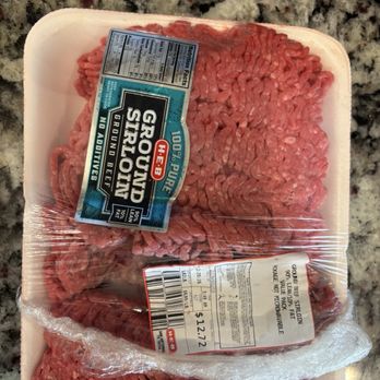 H-E-B - The image shows a plastic tray of ground beef, wrapped in clear plastic film, resting on a speckled granite countertop. The tray has multiple labels, including a large one from H-E-B with branding, weight, price, and product details. The ground beef appears fresh, with a red color and some visible fat. The packaging indicates it is ground beef, with nutritional facts and barcodes visible. - Grocery Near Me - Sugar Land, Texas