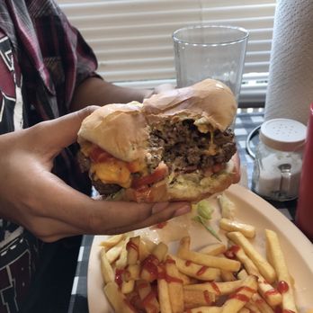 Derick's Cafe - a person holding a hamburger and fries - Sandwiches Near Me - Ninety Six, South Carolina Derick's Cafe - a person holding a hamburger and fries - Sandwiches Near Me - Ninety Six, South Carolina