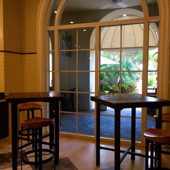 Key Pantry - a view of a kitchen with a table and stools - Cafes Near Me - Key Biscayne, Florida
