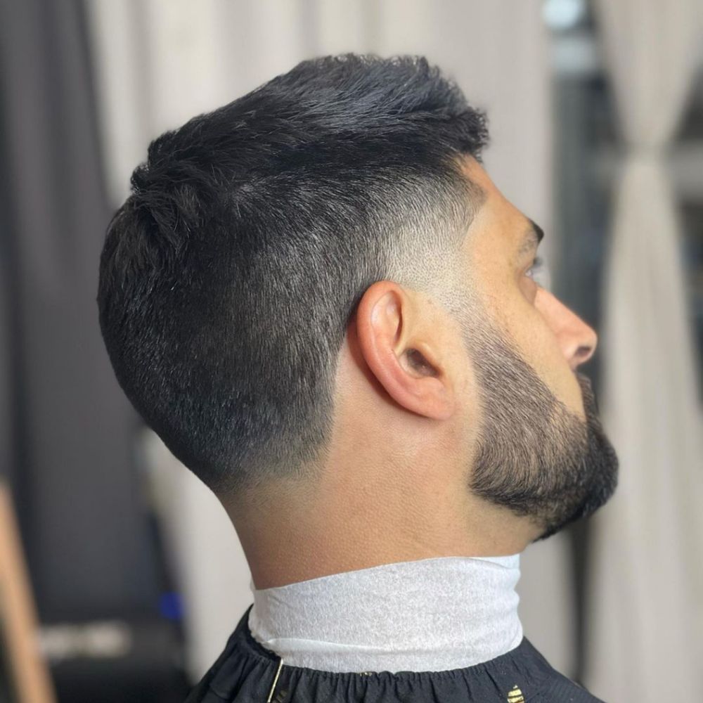 Low fade with textured scissor cut on top. Low fade with textured scissor cut on top.