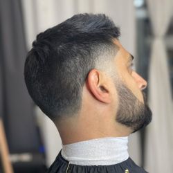 Grayscale Barbershop - Low fade with textured scissor cut on top.
