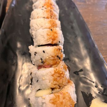 Bangkok Cuisine - a sushi roll on a black plate - Thai Near Me - Homestead, Florida Bangkok Cuisine - a sushi roll on a black plate - Thai Near Me - Homestead, Florida
