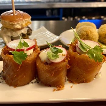 Bravas Tapas - Salmon 'Rulada' in the front, Morcilas de Burgos Sliders on left, Croquetas on the right - Spanish Near Me - London, XGL Bravas Tapas - Salmon 'Rulada' in the front, Morcilas de Burgos Sliders on left, Croquetas on the right - Spanish Near Me - London, XGL