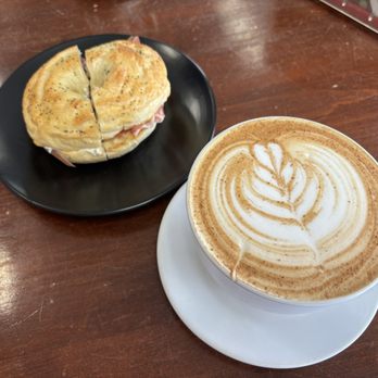 Sand Dust Coffee - Arroz con leche latte and bagel with cream cheese, prosciutto and tomato. - Coffee & Tea Near Me - El Paso, Texas