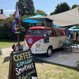 a vw bus parked in front of a coffee shop a vw bus parked in front of a coffee shop
