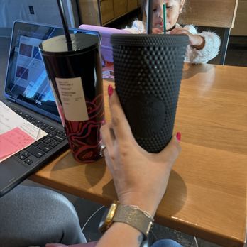Starbucks - a woman sitting at a table with a cup of coffee in front of her - Coffee & Tea Near Me - Mount Pleasant, South Carolina Starbucks - a woman sitting at a table with a cup of coffee in front of her - Coffee & Tea Near Me - Mount Pleasant, South Carolina
