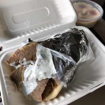 Grab A Gyro - Lamb gyro with a side of hummus in the background. - Mediterranean Near Me - Tualatin, Oregon