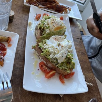 Cafe Diem - Avocado toast on sourdough bread with a poached egg and a side of bacon - Cafes Near Me - Pearl River, New York