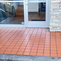 McDonald's - Freshly mopped tile in front of the door. Left wet with no warning sign.