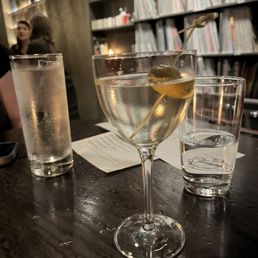 Japanese whiskey high ball in the back and dirty martini in the front
