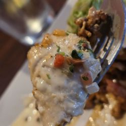 El Costéno Mexican Grill - A fork holding a piece of the King Burrito, including Premium Steak, Grilled Chicken, Shrimp, and Chorizo.