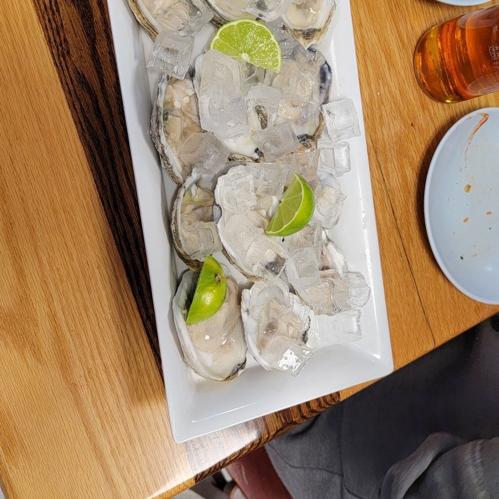 a plate of oysters with lime wedges a plate of oysters with lime wedges
