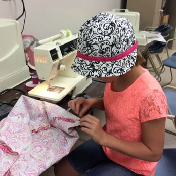 PoldaPop Designs - Sewing student working on a tote bag wearing a hat made in class. - Sewing & Alterations Near Me PoldaPop Designs - Sewing student working on a tote bag wearing a hat made in class. - Sewing & Alterations Near Me