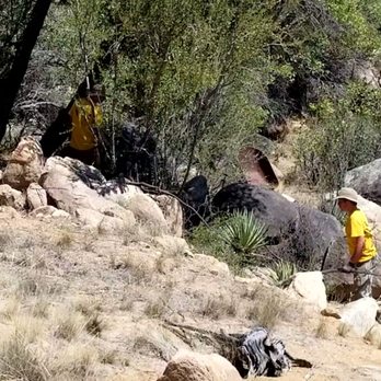 Arbor Art - a man in a yellow shirt and hat standing in a rocky area - Landscaping Near Me Arbor Art - a man in a yellow shirt and hat standing in a rocky area - Landscaping Near Me