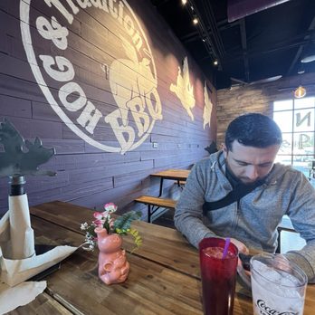 Hog & Tradition - Cute restaurant logo painted on the wall. Love the wood pic I style tables. - Barbeque Near Me - Henderson, Nevada