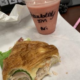 a half eaten sandwich and a drink