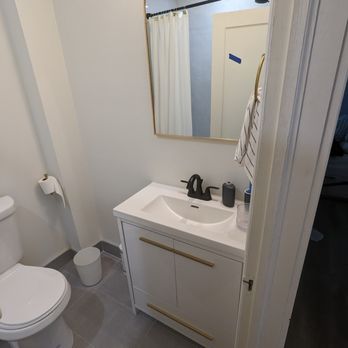 S B Reno - a bathroom with a sink, toilet and mirror - General Contractors Near Me S B Reno - a bathroom with a sink, toilet and mirror - General Contractors Near Me