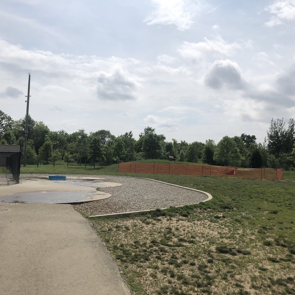Heritage Trail Dog Park - Blocked off area in the background,pebbled area and splash pad in the foreground - Dog Parks Near Me - Hilliard, Ohio