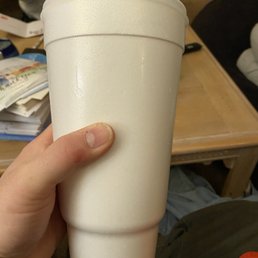 a person holding a white cup