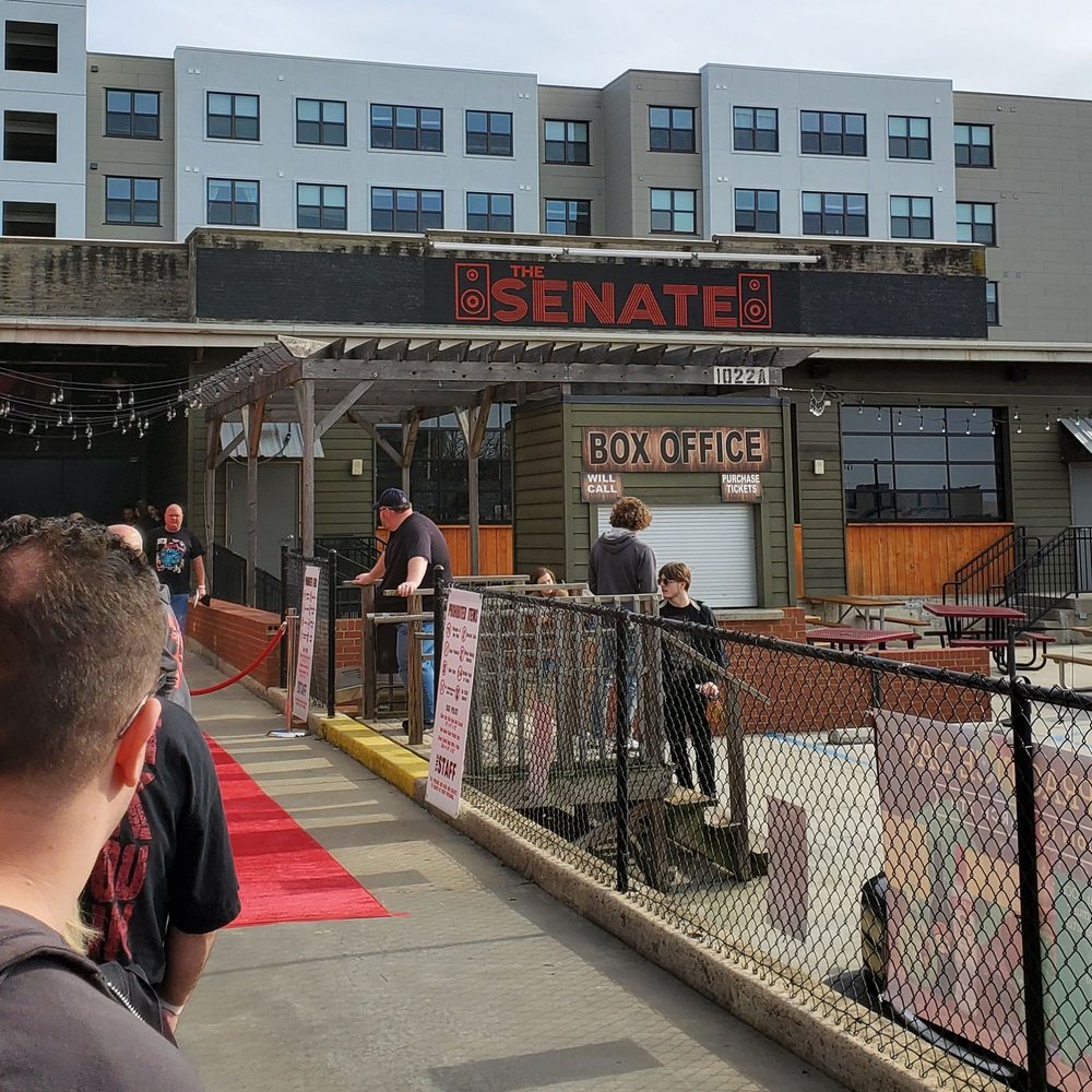 a crowd of people standing outside of a building a crowd of people standing outside of a building