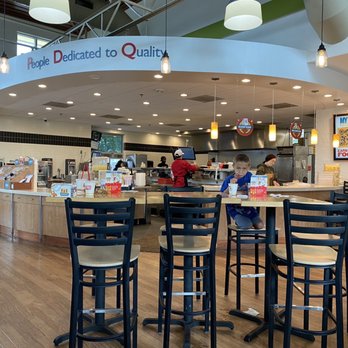 PDQ - the interior of a restaurant with tables and stools - Fast Food Near Me - Wellington, Florida PDQ - the interior of a restaurant with tables and stools - Fast Food Near Me - Wellington, Florida