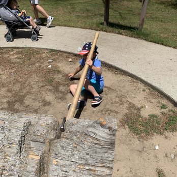 Lumberman's Monument Visitor Center - Grandson using one of the logging tools of the time and finding out it was not that easy - Visitor Centers Near Me - Oscoda, Michigan