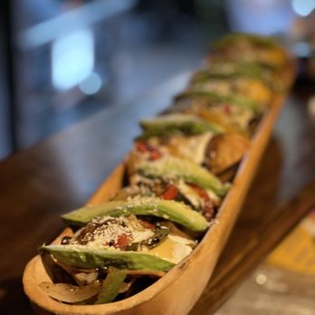 Los Dos Hermanos - a long wooden boat of food - Tapas Bars Near Me - Brooklyn, New York