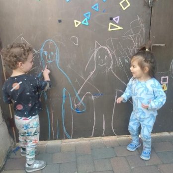 Semillitas Bilingues - Two amigos sharing smiles and their chalk creations. - Child Care & Day Care Near Me
