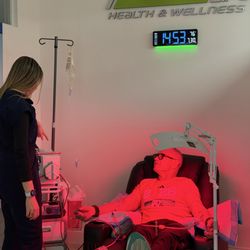 Patient receiving EBOO therapy with RN Vivi by their side, paired with Red Light Therapy for a personalized wellness experience.