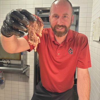 GQue BBQ - Nick showcasing a piece of slow-smoked brisket - Barbeque Near Me - Timnath, Colorado GQue BBQ - Nick showcasing a piece of slow-smoked brisket - Barbeque Near Me - Timnath, Colorado
